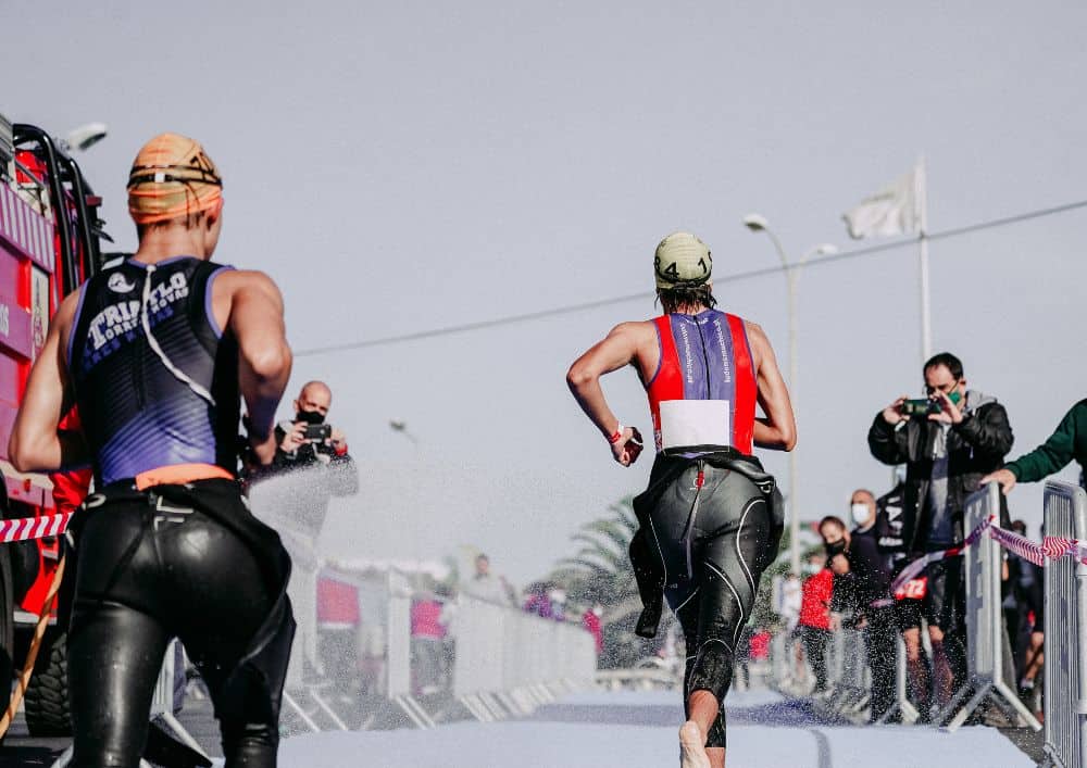 Triathlètes en combinaison quittant le parc à vélos
