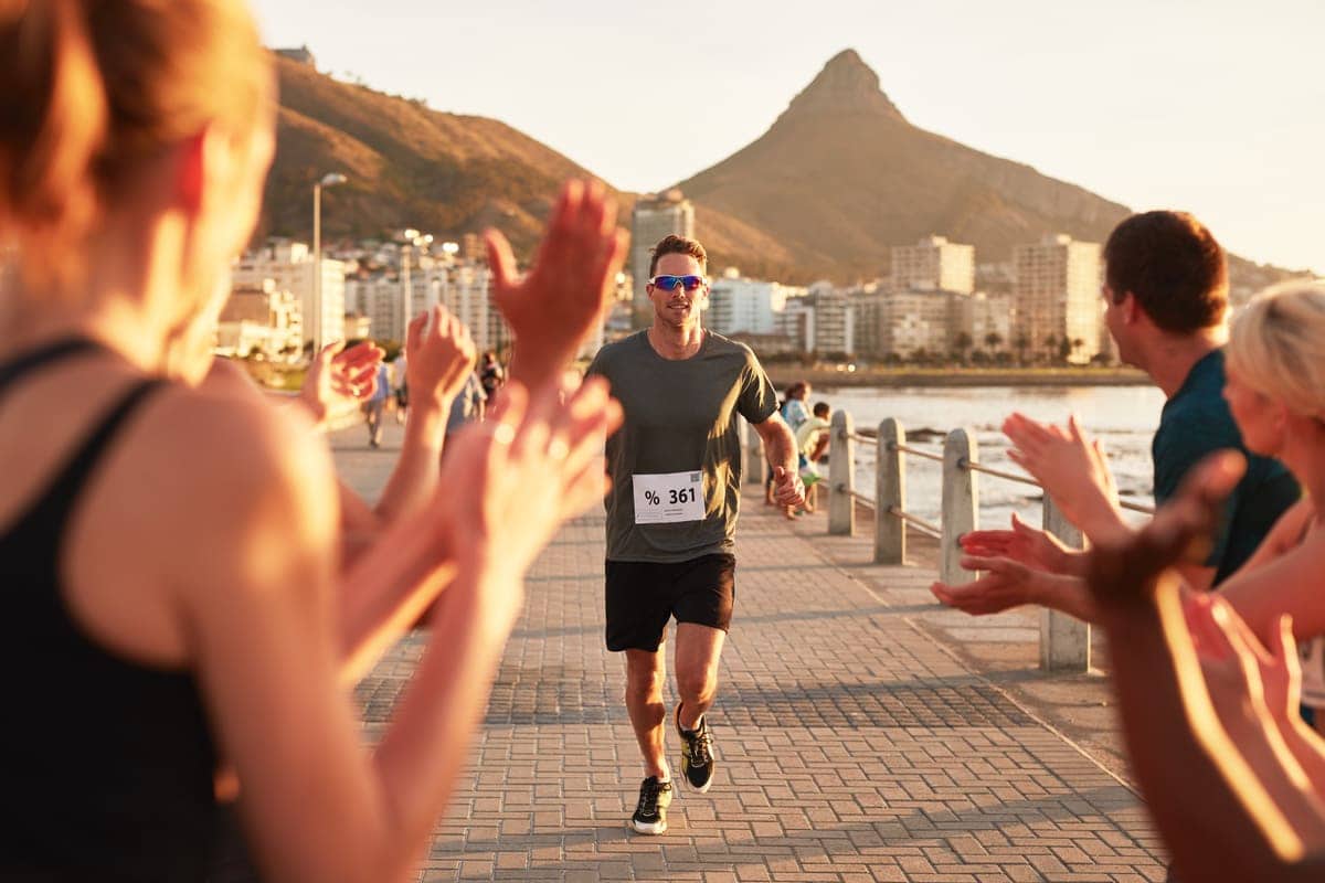 Coureur franchissant l'arrivée encouragé par le public