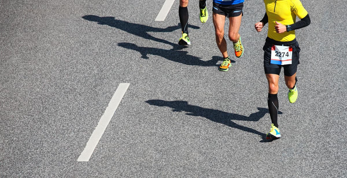 Coureurs et leurs ombres portées sur la route pendant une course