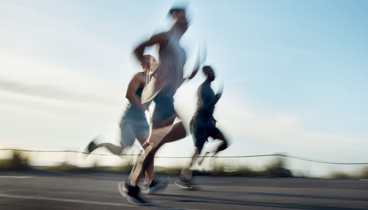 Coureurs en mouvement saisis en filé sur une route